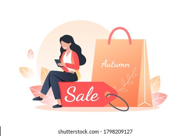 A young woman holds a smartphone in her hands and sits on a discount tag. Gifts and purchases, autumn sales and online shopping. Vector illustration