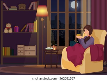 Young woman at home sitting in soft chear relaxing in her living room and drinking coffee or tea. Girl rests in night interior