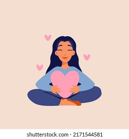 A young woman hugs a big red heart with care and love. A smiling female character sits in a lotus position with her eyes closed and enjoys freedom and life. Body positive and mental health concept.