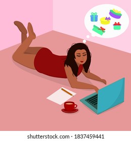 a young woman lies on the floor on her stomach in front of a laptop and orders holiday gifts online