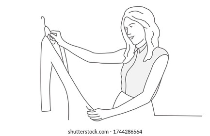 Young woman looks at a dress on a hanger. Line drawing vector illustration.