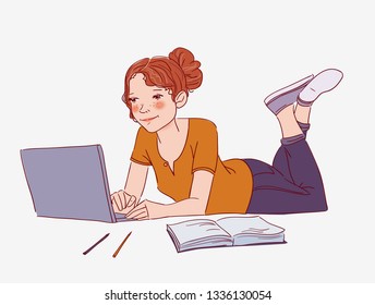 Young woman lying on the floor and  working on laptop