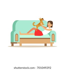Young woman lying on a light blue sofa and playing with her puppy, woman resting at home vector Illustration
