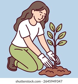 Jonge vrouw plant kleine boom in de grond, draagt handschoenen en knielt op de grond, symboliseert eco-zorg en duurzaamheid