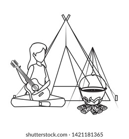 young woman playing guitar with camping tent and campfire