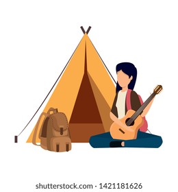 young woman playing guitar with camping tent and travelbag