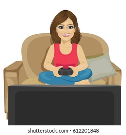Young woman playing video game at home sitting on sofa