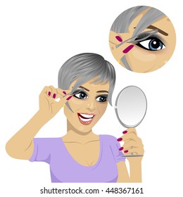 young woman plucking her eyebrows with tweezers looking at mirror