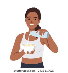 Young woman preparing healthy breakfast adding milk to plate after morning fitness or sports. 