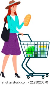 Young woman pushing shopping cart full of groceries. Girl with grocery cart makes purchases, buys goods in supermarket. Lady with grocery trolley holding bread. Shopping in modern store concept