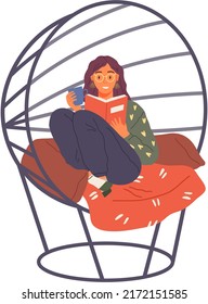 Young woman reading book, sitting on pillows in modern chair. Leisure and education. Relaxation with literature. Girl relaxing at home and drinking coffee. Student reads textbook holds cup in hand