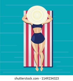 Young woman in a retro swimsuit with a straw hat relaxing on the red and white striped mattress on the sea in summer
