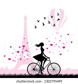 young woman riding bike with Eiffel tower and hot air balloon in behind