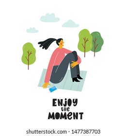 A young woman sits and dreams in a park. Illustration of a girl in a modern style. Motivation lettering quote - enjoy the moment