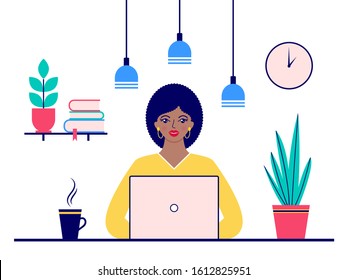Young woman sitting at desk and working on laptop