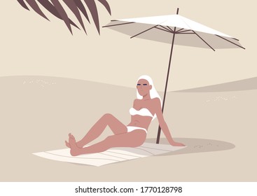 Young woman sitting on the beach under umbrella, summertime vacation, hot tropical climate