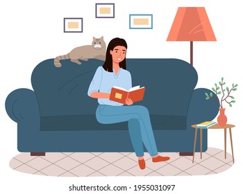 Young woman is sitting on couch and reading book. Female pet owner with literature at home