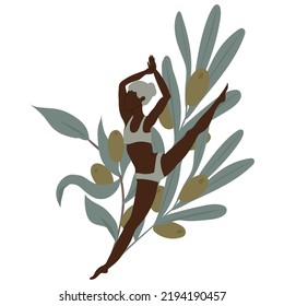 Young woman split jumping in front of olive branches.