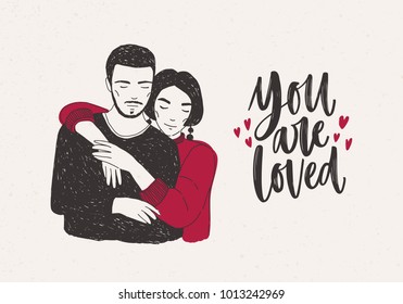 Young woman standing behind man and warmly embracing him and You Are Loved hand lettering decorated with tiny hearts. Loving romantic couple. Vector illustration for Valentine’s day greeting card.