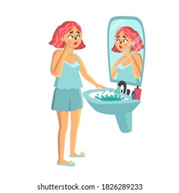young woman standing in front of mirror. girl with a pimple