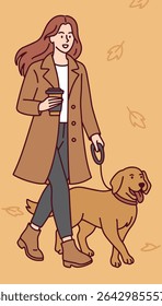 Young woman in stylish autumn coat walks her dog with coffee in hand on leaf-covered street enjoying peaceful seasonal moment