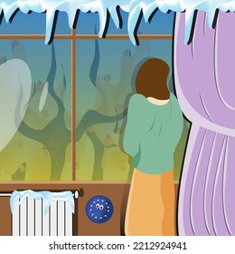 A young woman in a sweater, skirt stands at the window with an autumn landscape with a radiatorand a curtain with icicles. The concept of saving heating in the European Union. 
