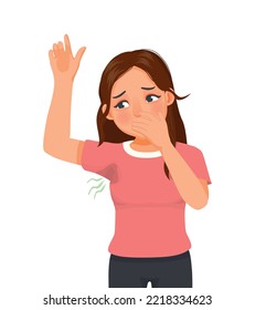 Young woman sweating under her armpit stain on her clothes with smelly odor 
