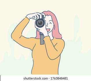 Young woman taking a photo with a camera. Hand drawn in thin line style, vector illustrations.