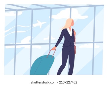 Young woman walks through an airport with a suitcase