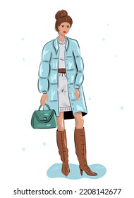 A young woman in winter in a down jacket, boots and with a bag.