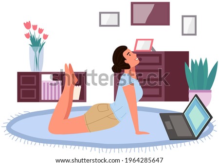 Young woman working out doing exercises at home. Girl doing yoga on mat. Sportswoman stretches in apartment. Yogi performs physical exercise by video on computer. Healthy lifestyle and sports activity