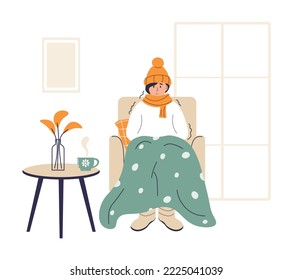 Young woman wrapped in plaid. Frozen female character in hat and scarf. Low temperature at home. Person freezes from cold warming up with hot drink. Girl sitting in armchair, shivering from cold.