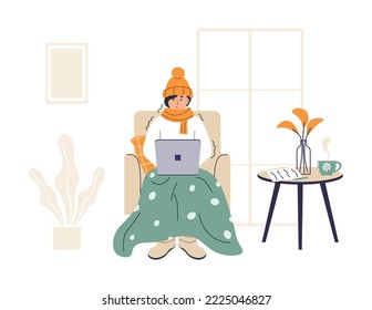 Young woman wrapped in plaid is working on laptop. Low temperature at home. Person freezes from cold warming up with hot drink. Girl sitting in chair in warm clothes. Frozen and shivering character.