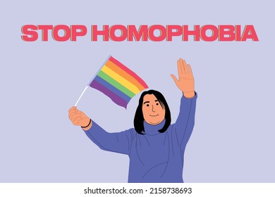 Young women holding lgbt flag and say stop homophobia at a gay pride parade - Stop homophobia