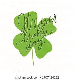 It’s your lucky day calligraphy saying for St. Patrick’s day banner or card. Vector hand drawn four-leaf shamrock vector clipart as background image.