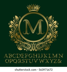 Zigzag striped gold letters and initial monogram in coat of arms form with crown. Elegant font and elements kit for logo design.