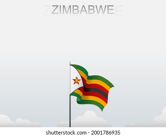 La bandera de Zimbabue ondea sobre un poste alto bajo un cielo blanco