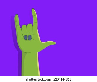 Zombie hand making rock gesture on purple background with right side copyspace. Person with green make up disguise for Halloween party