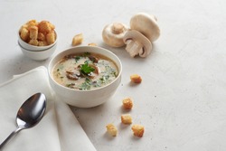 Tasty mushrooms soup with croutons on a white table. Healthy diet concept. Photo with selective focus with pace for your text.