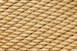 Diagonal strands of a new thick sisal and hemp rope with twisted braided fibers in a full frame close up background texture