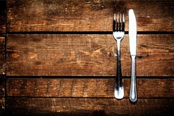 Silver Knife and fork over wooden table with copy space. Diet Food concept.