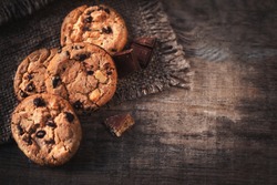 Chocolate chip cookies on dark old wooden table with place for text.,  freshly baked. Selective Focus with Copy space.