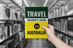 Travel insider's guide book to visiting Australia with library on the background.