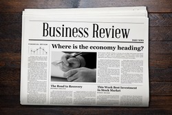 Business Newspaper on wooden background.