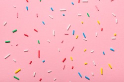 colorful sprinkles over pink background, decoration for cake and bakery 