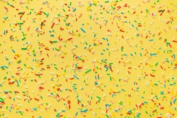 colorful sprinkles over yellow background, decoration for festive Valentines day, birthday, holiday and party time