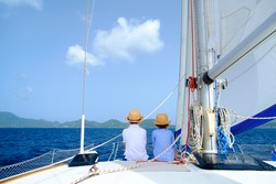 Back view of kids enjoying sailing on a luxury catamaran or yacht