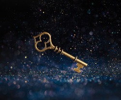 Single golden skeleton key surrounded by sparkling lights. Business concepts of unlocking potential, key to success, or financial opportunity.