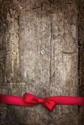 Decorative red ribbon and bow over wooden background/holidays background with copyspace