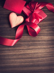 REd Holidays gift and heart on wooden background/ Valentines day background